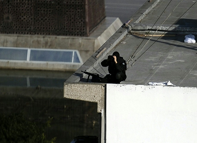 protests in tunisia: A Tunisian police sniper looks through b