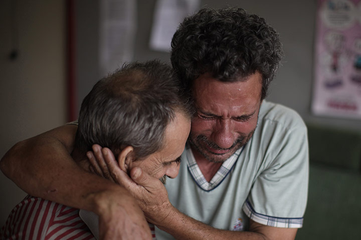 Felipe Dana in Brazil: Paulo Rodrigues da Silva, right, reacts as he embraces a relative