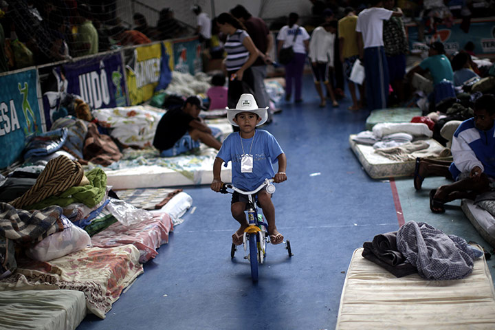 Felipe Dana in Brazil: A boy rides his tricycle in a stadium being used as a shelter