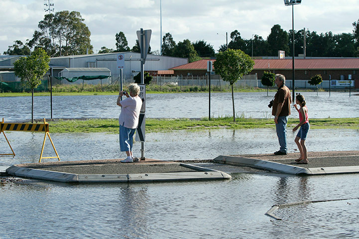 Victoria flood: Onlookers take photos of a flooded street near the Wimmera River