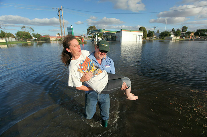 Victoria flood: Phil Barnard carrying his wife Jan across a flooded street in Horsham