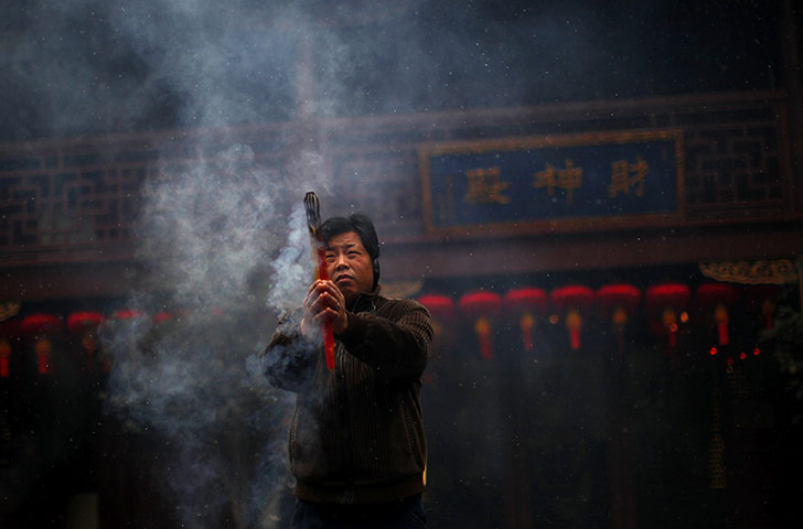 24 hours in pictures: A man burns incense a temple in the old city of Shanghai