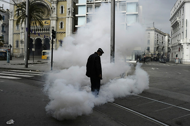 Tunis protest: A policeman stands in a cloud of teargas in Tunis
