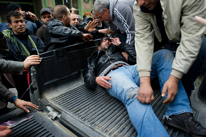 Tunis protest: A wounded Tunisian man is taken away by fellow protesters