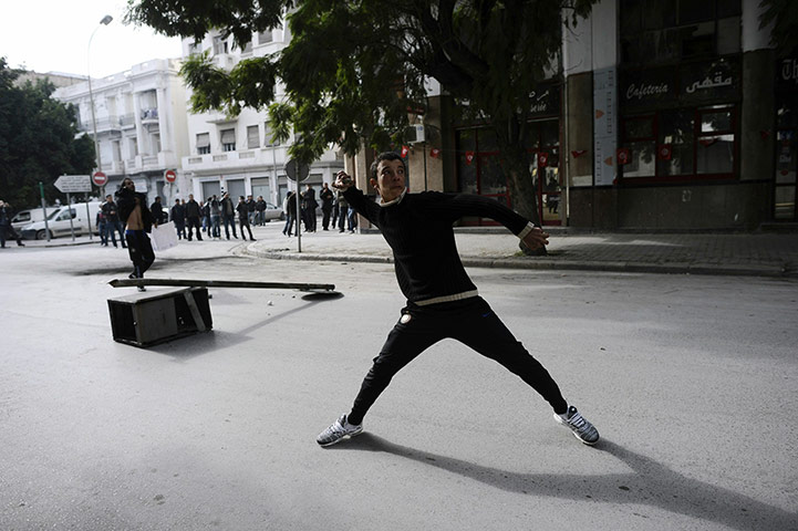 Tunis protest: A Tunisian protester prepares to throw a stone during a demonstration