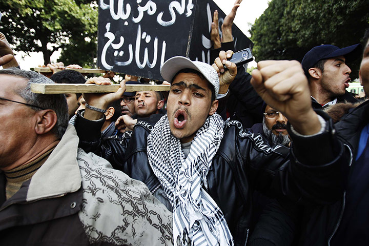 Tunisia uprising: Protesters carry a fake coffin during a demonstration in downtown Tunis