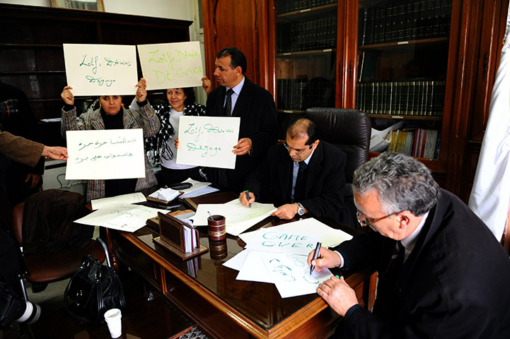 Tunisia update: Tunisian judges hold placards as they demonstrate inside Tunis' courthouse