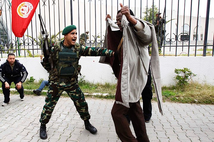 Tunisia protests: Protester ducks during gun fire at a demonstration in downtown Tunis