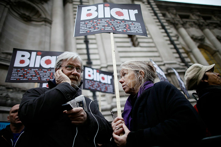 blair at iraq inquiry: Members of the public listen on a radio