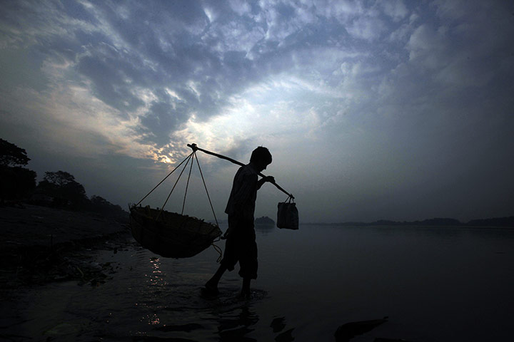 24 hours in pictures: A vegetable seller walks in the Brahmaputra River 