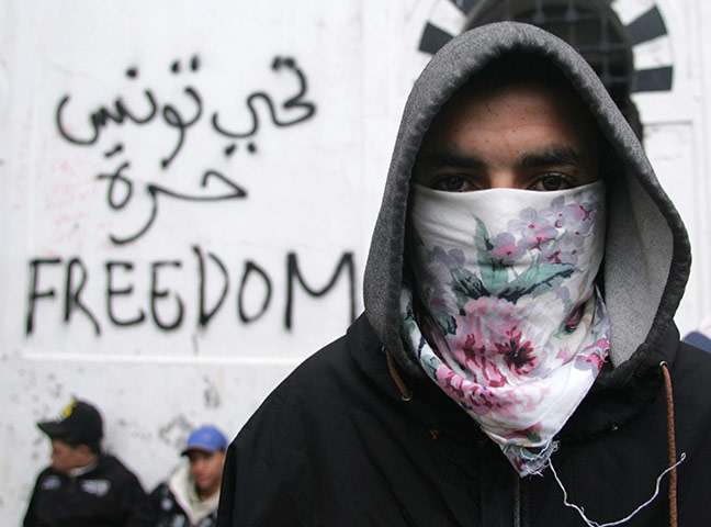 Tunisia Protests: A Tunisian protester stands near a wall