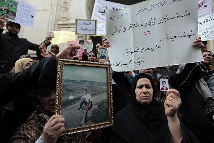 Tunisia Protests: Tunisian women hold photographs of their sons outside the Justice Ministry