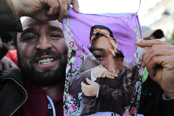 Tunisia Protests: Protesters hold up a torn picture of ousted leader Zine al-Abidine Ben Ali