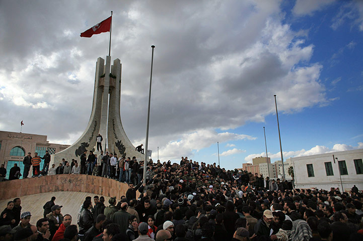 Tunisia Protests: Protesters climb on to the City Hall Monument