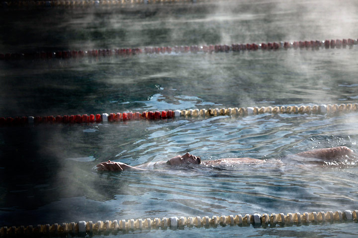 24 hours in pics: A man swims in a heated outdoor pool in sub freezing temperatures