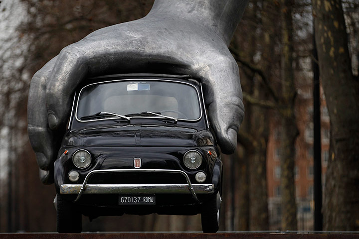 24 hours in pics: A Fiat 500 gripped by an aluminum hand sculpture Vroom Vroom in London