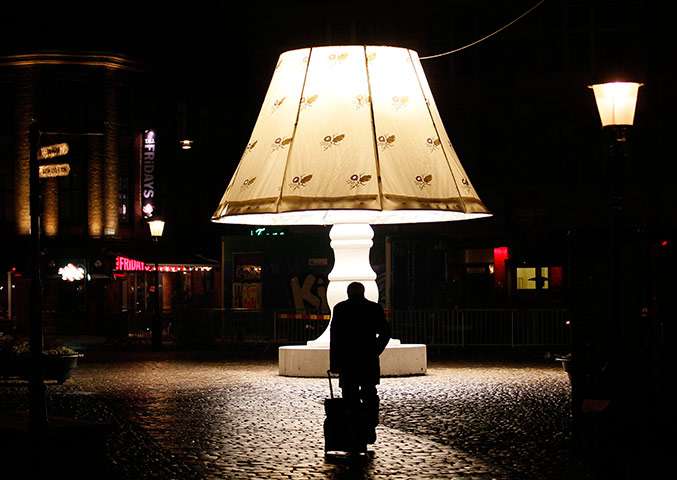 24 hours in pics: A man walks past a giant lamp placed on Lilla Torg square in Malmo