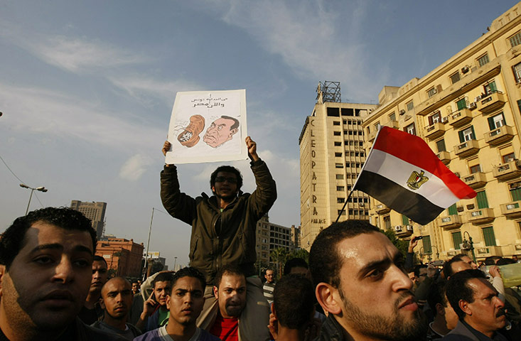 egpyt protests: Egyptian demonstrators hold up placards of Hosni Mubarak