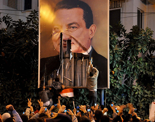 Egypt protests: Demonstrators deface a poster of Egyptian President Hosni Mubarak