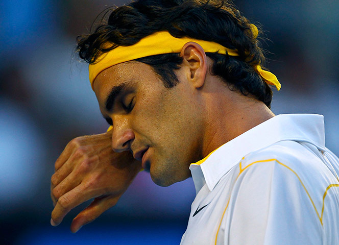 Melbourne Day 11: Federer of Switzerland wipes his face during his semi-final again Djokovic