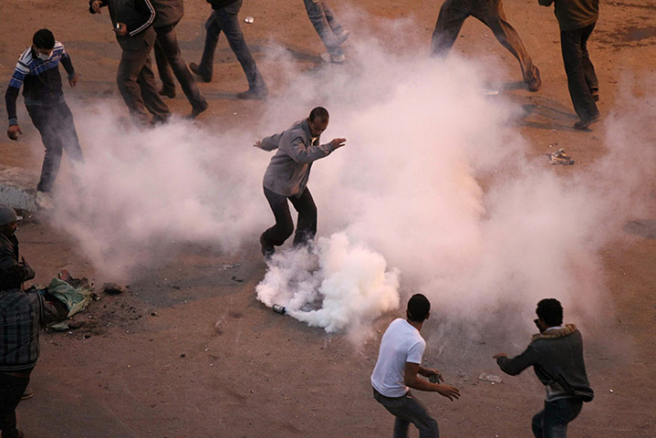 Egypt violence continues: Egyptian demonstrators try to remove a tear gas canister in Suez