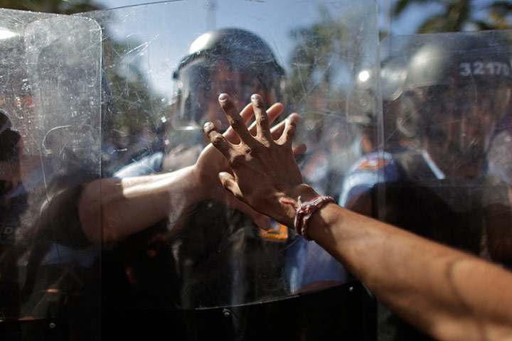 24 hours in pictures: A demonstrator touches the shield of a riot police 