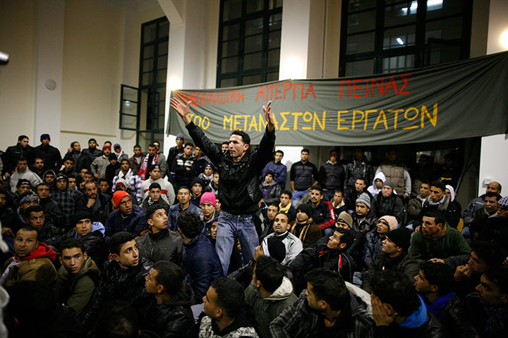 24 hours in pictures: Immigrants sit at the entrance hall of the Athens Law School