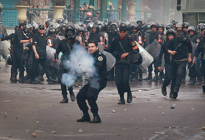 Egypt Protests: A riot policeman fires tear gas at protestors in Cairo