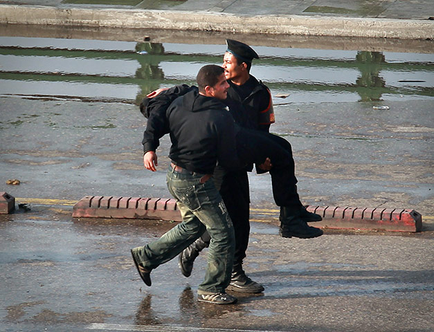 Egypt protests Cairo: Police carry an injured colleague across the Kasr Al Nile Bridge, Cairo