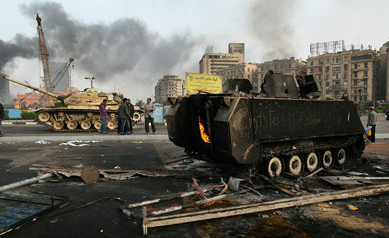 Egypt 29 January: An army tank and a burnt out armoured personnel carrier in Tahrir Square