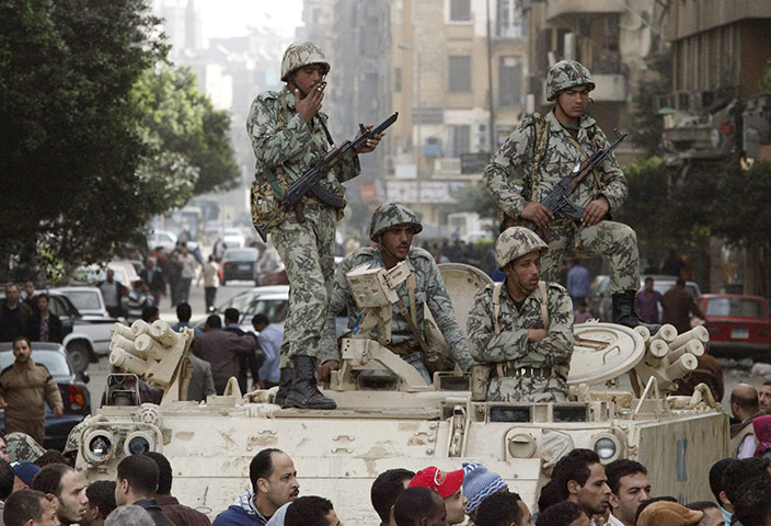 Egypt 29 January: Egyptian soldiers stand on top of an armoured vehicle in Cairo