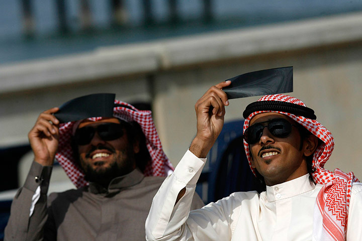 eclipse: Kuwaiti men look through special filters at a partial solar eclipse