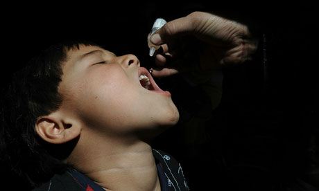 An Afghan health worker administers polio vaccine