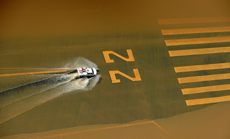 Australia floods: A vehicle drives down the flooded runway at Rockhampton Airport