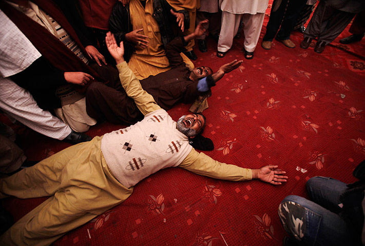 24 hours in pictures: Pakistani mourners lay on the ground crying