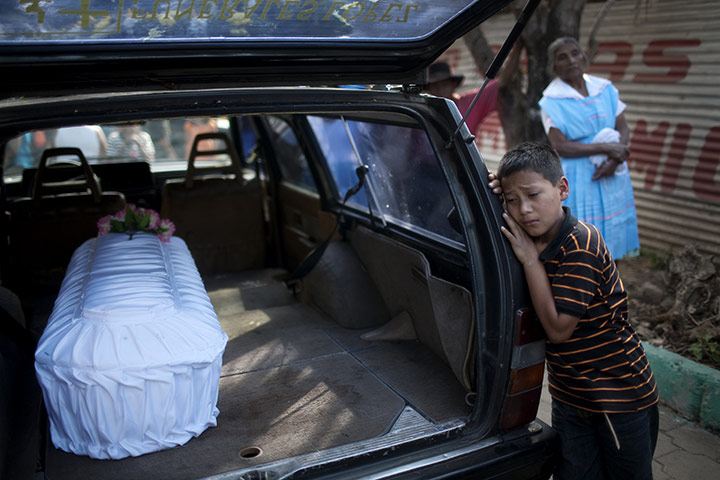 24 hours: Guatemala City, Guatemala: Jason Nataeli stands next to his cousin's coffin