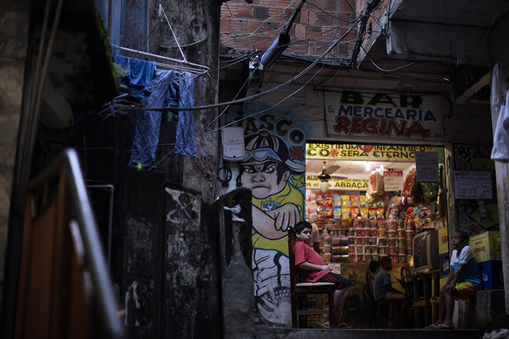 24 hours: Rio de Janeiro, Brazil: Boys sit outside a store in the Santa Marta slum