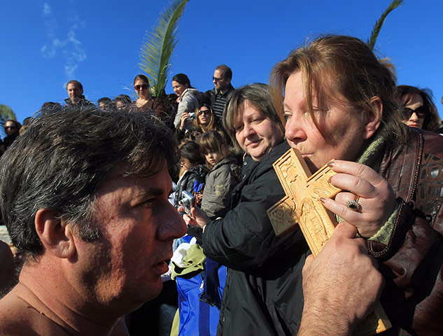 Orthodox Christmas: A man blesses a woman with a wooden cross