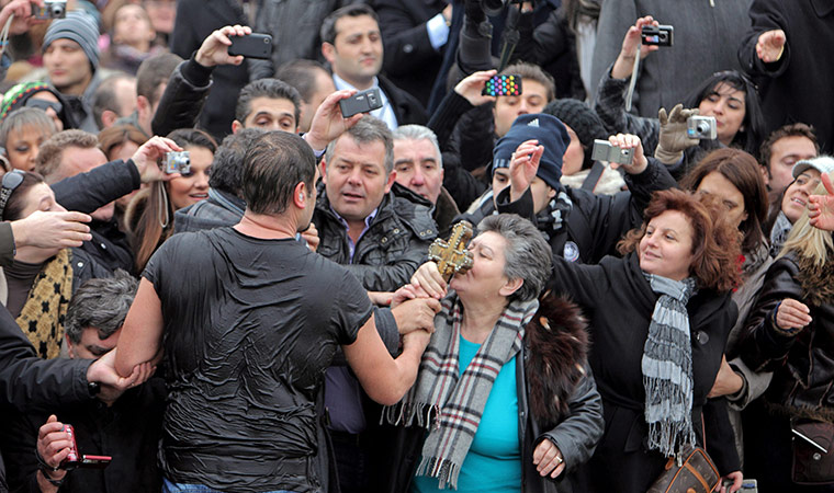 Orthodox Christmas: Greek Orthodox people kiss the wooden crucifix 