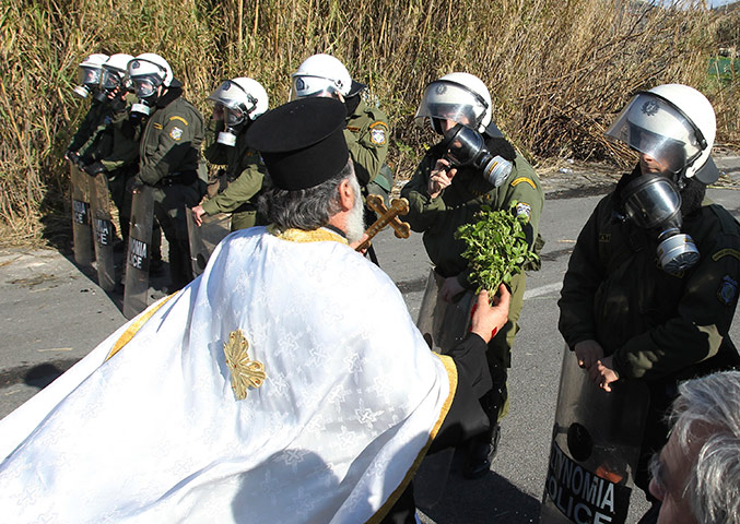 Orthodox Christmas: A Greek Orthodox priest blesses riot police 