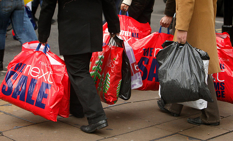 Week in business: Shoppers carry bags from the post Christmas sales on Oxford Street
