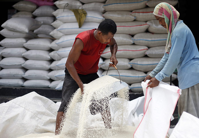 Business week in pictures: Indonesian workers load rice in to a sack at a market in Jakarta
