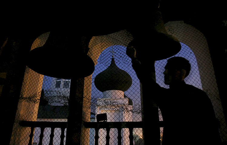 Orthodox Christmas: A bell ringer is silhouetted as he stands at the tower of a cathedral