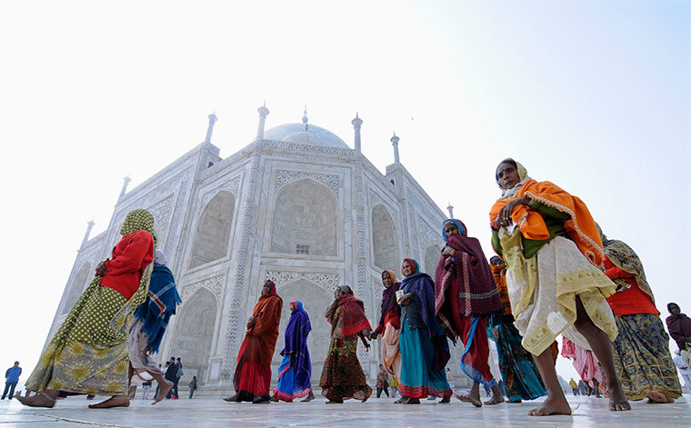 24 hours in pictures: A group of women walk at the historic Taj Mahal in Agra