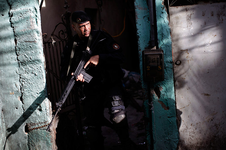 24 hours in pictures: A police officer patrols the Morro Sao Joao slum in Rio de Janeiro