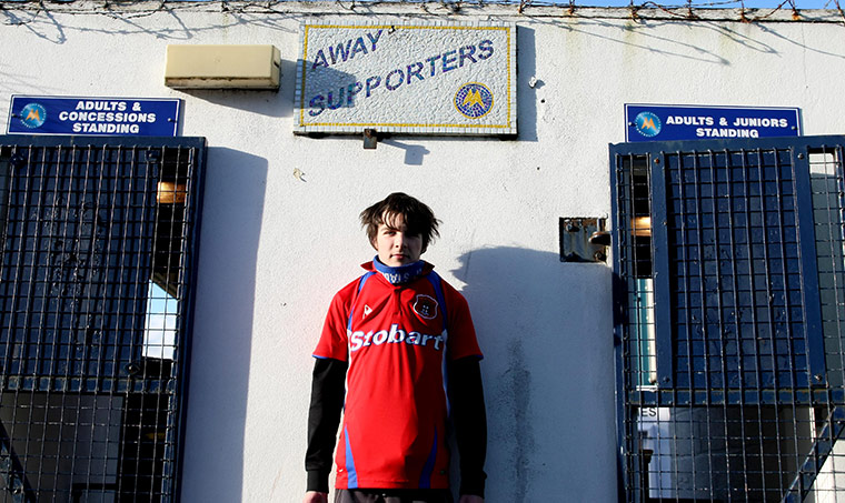 Torquay v Carlisle: A Carlisle United fan waits by the closed turnstiles