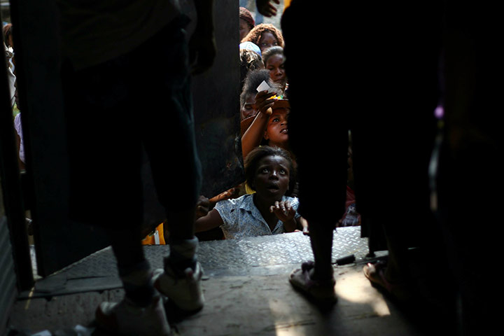24 hours: Puerto Principe, Haiti: A group of people wait for food supplies 