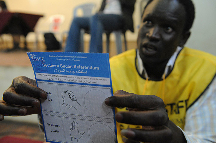 Sudan referendum: An official shows a ballot paper to a South Sudanese man living in Kenya