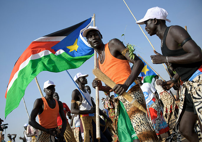Sudan referendum: A group of southern Sudanese men wave local flags and dance