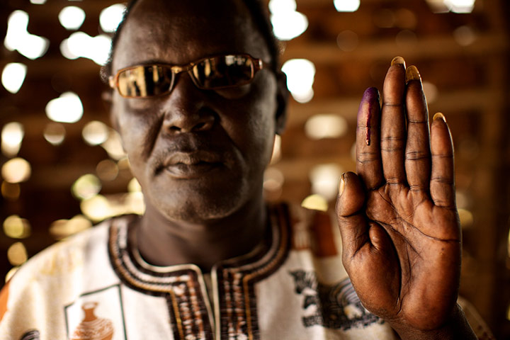 Sudan voters: Chief Michael Aburi holds up his ink-stained finger to show he voted